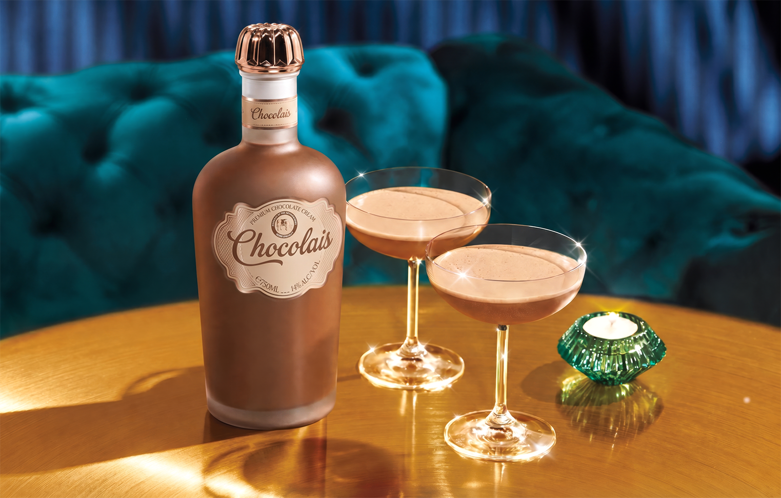 Chocolais-fles met twee gevulde cocktailglazen op een gouden tafel